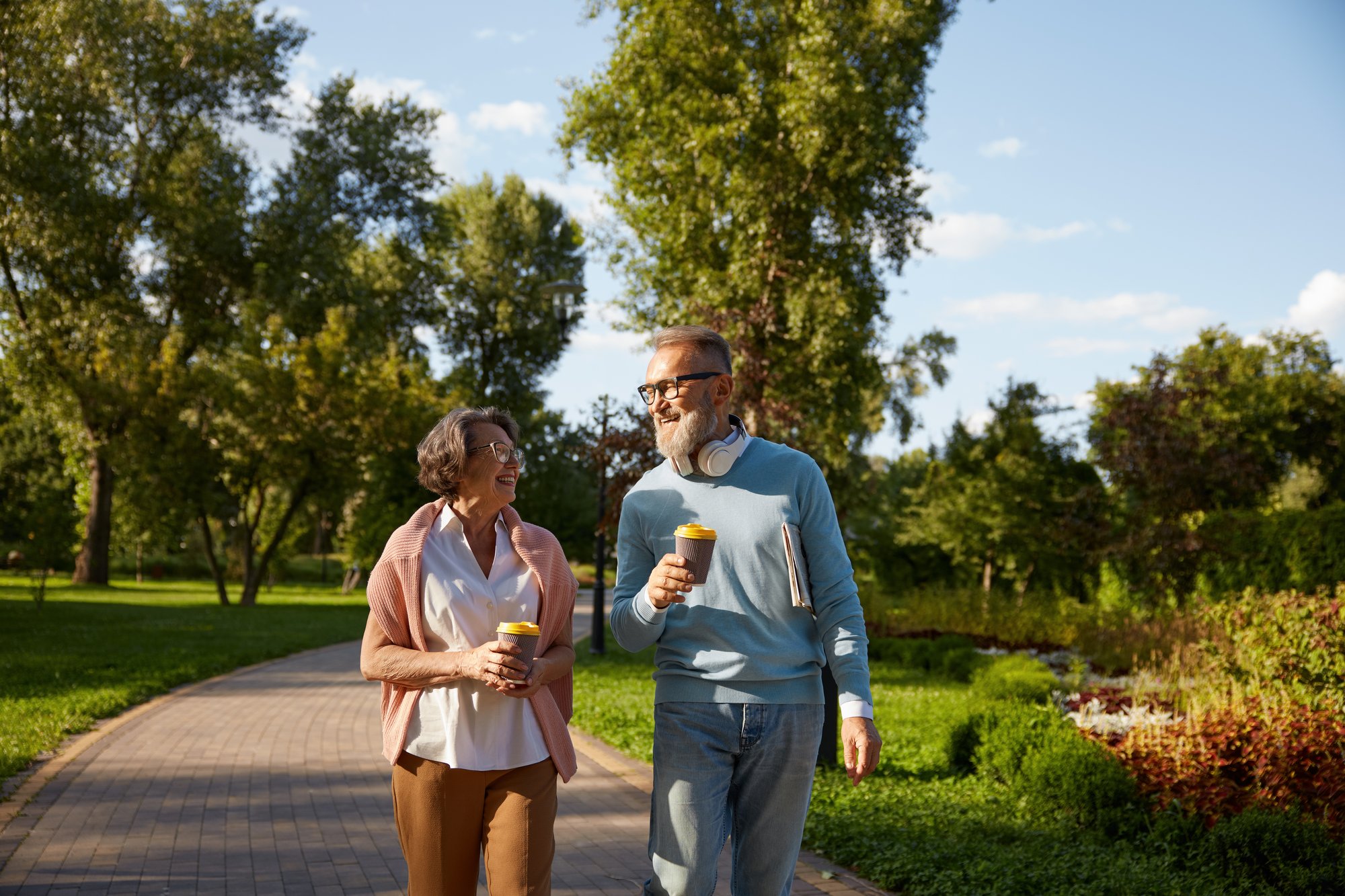 happy-elderly-couple-having-coffee-break-walking-park