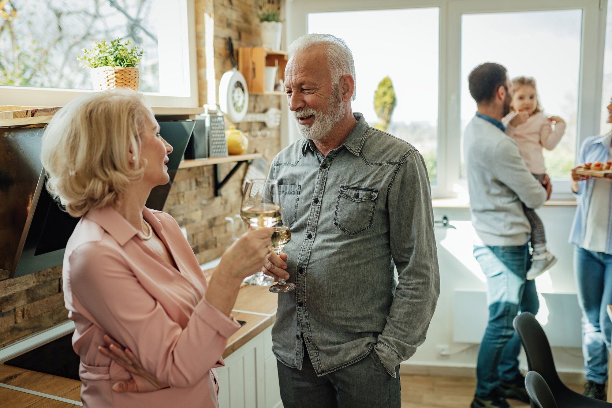 happy-mature-couple-toasting-with-wine-before-family-lunch-kitchen-focus-is-man-1